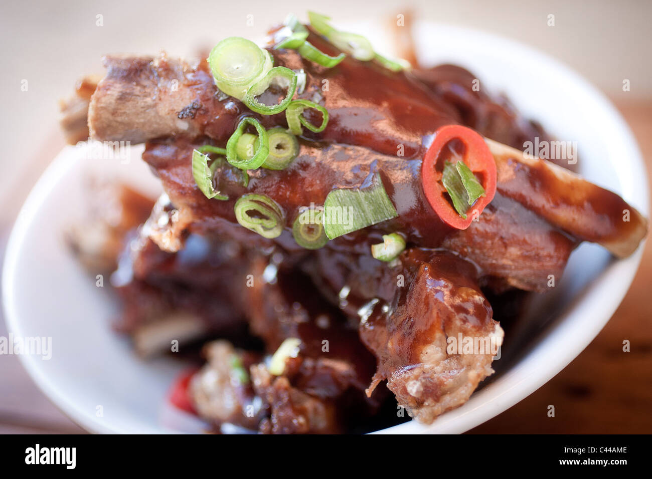 A gourmet dish of sticky Chinese style spare ribs served with chili, ginger and spring onions Stock Photo