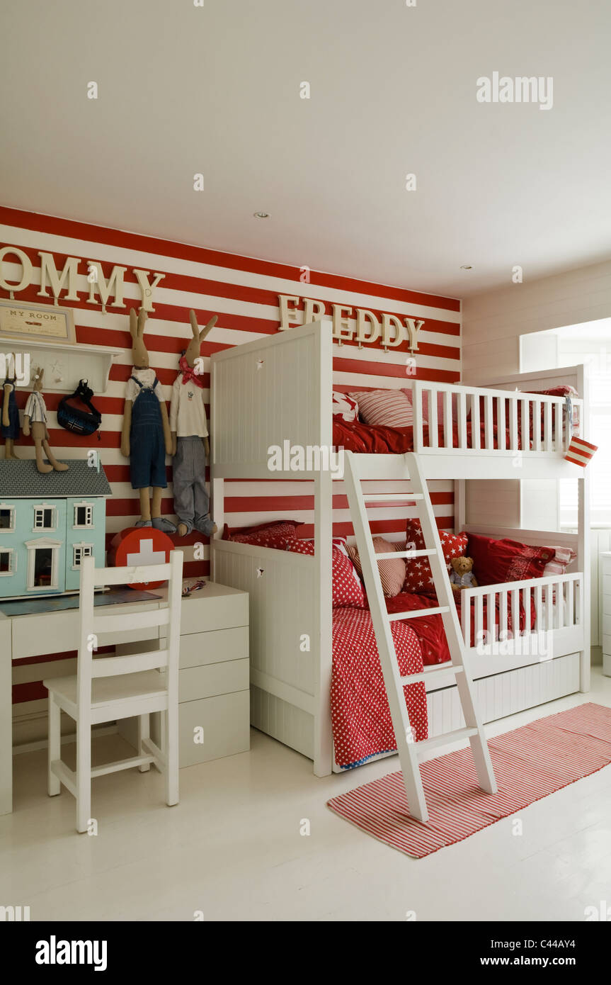Childs bedroom with bunk bed, dolls house, striped wall and wall lettering Stock Photo
