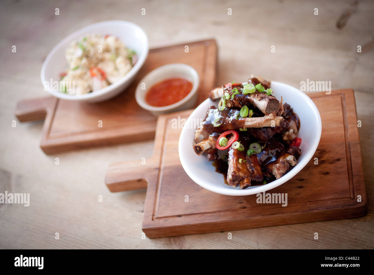A dish of Chinese sticky pork ribs served with rice noodles and sweet