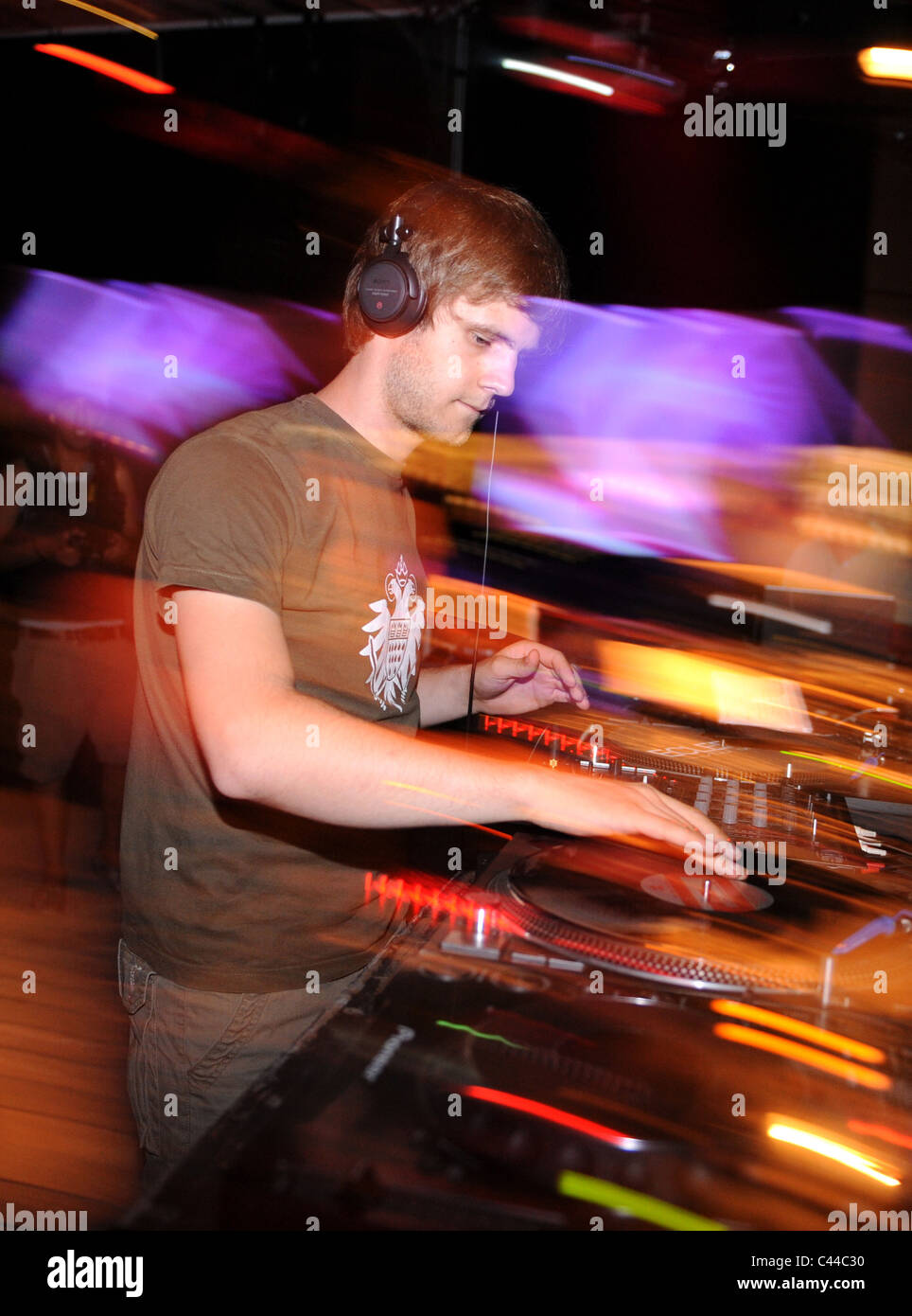 Young DJ playing vinyl records in a night club Stock Photo