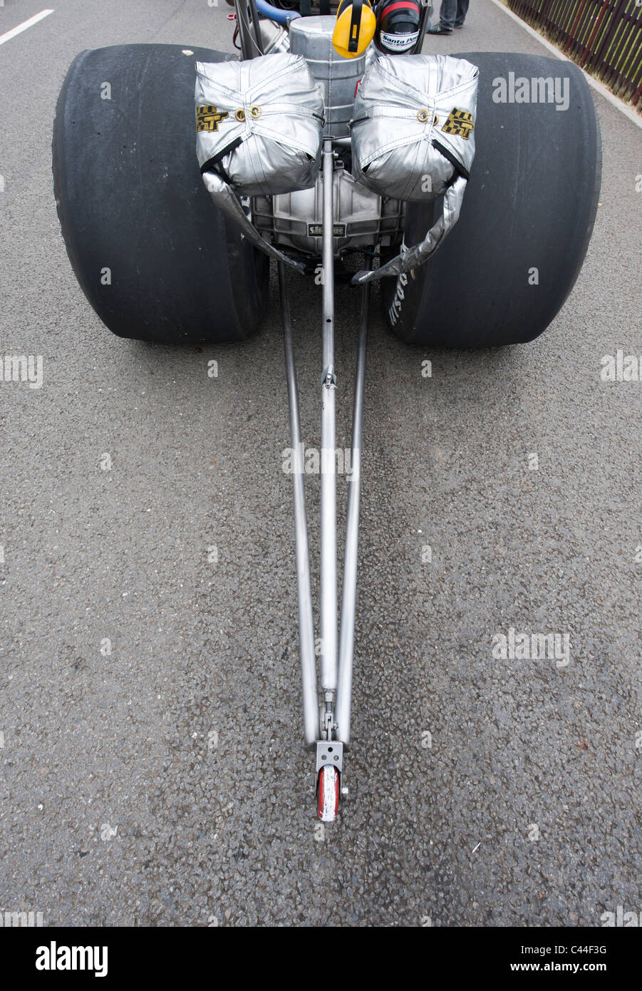 Rear view of dragster showing wheelie bars and parachutes. Wide angle