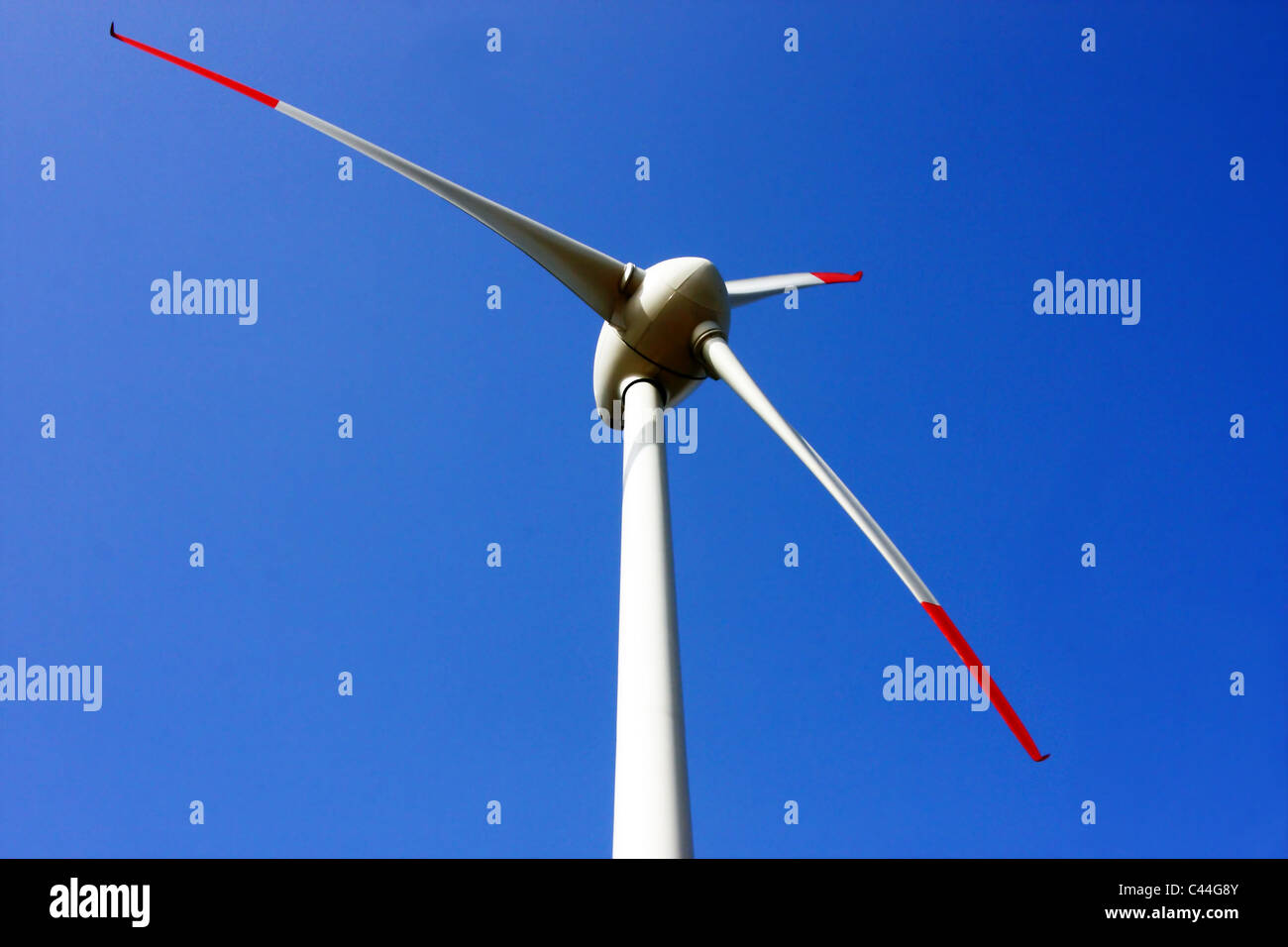 Wind turbine with bright blue sky in background Stock Photo - Alamy