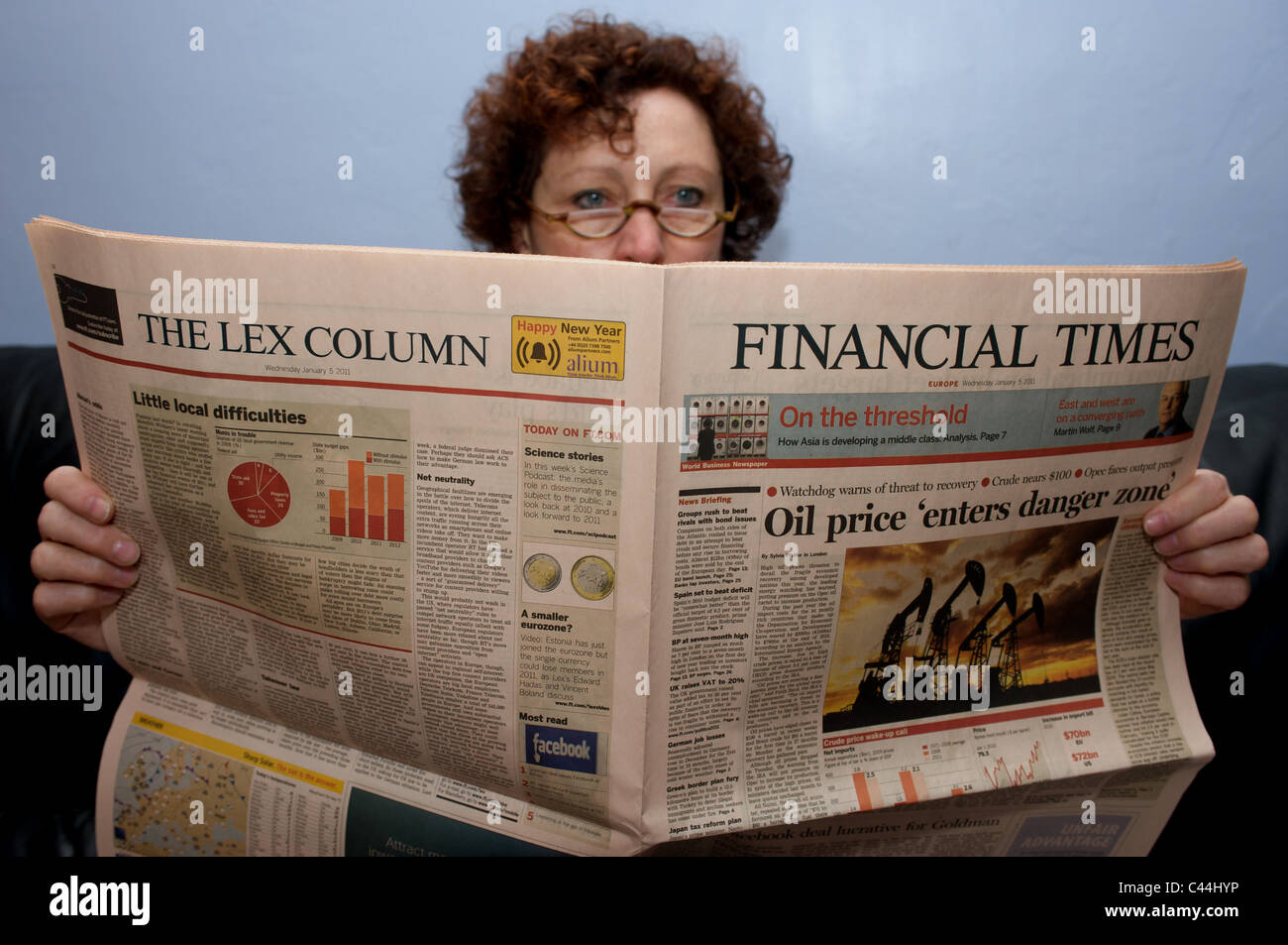 Woman reading a copy of the Financial Times European edition Stock Photo