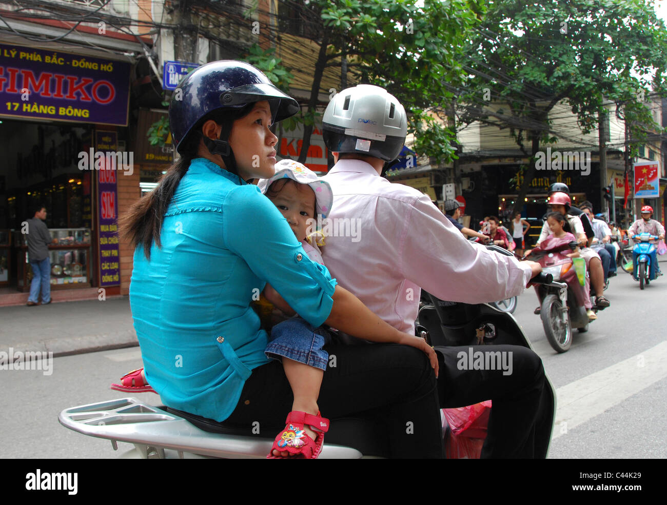 Vietnamese family on scooter in rush hour traffic Hanoi Stock Photo