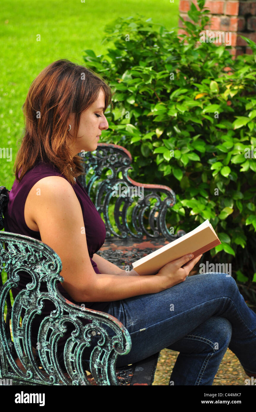 A young woman reading a book outdoors Stock Photo