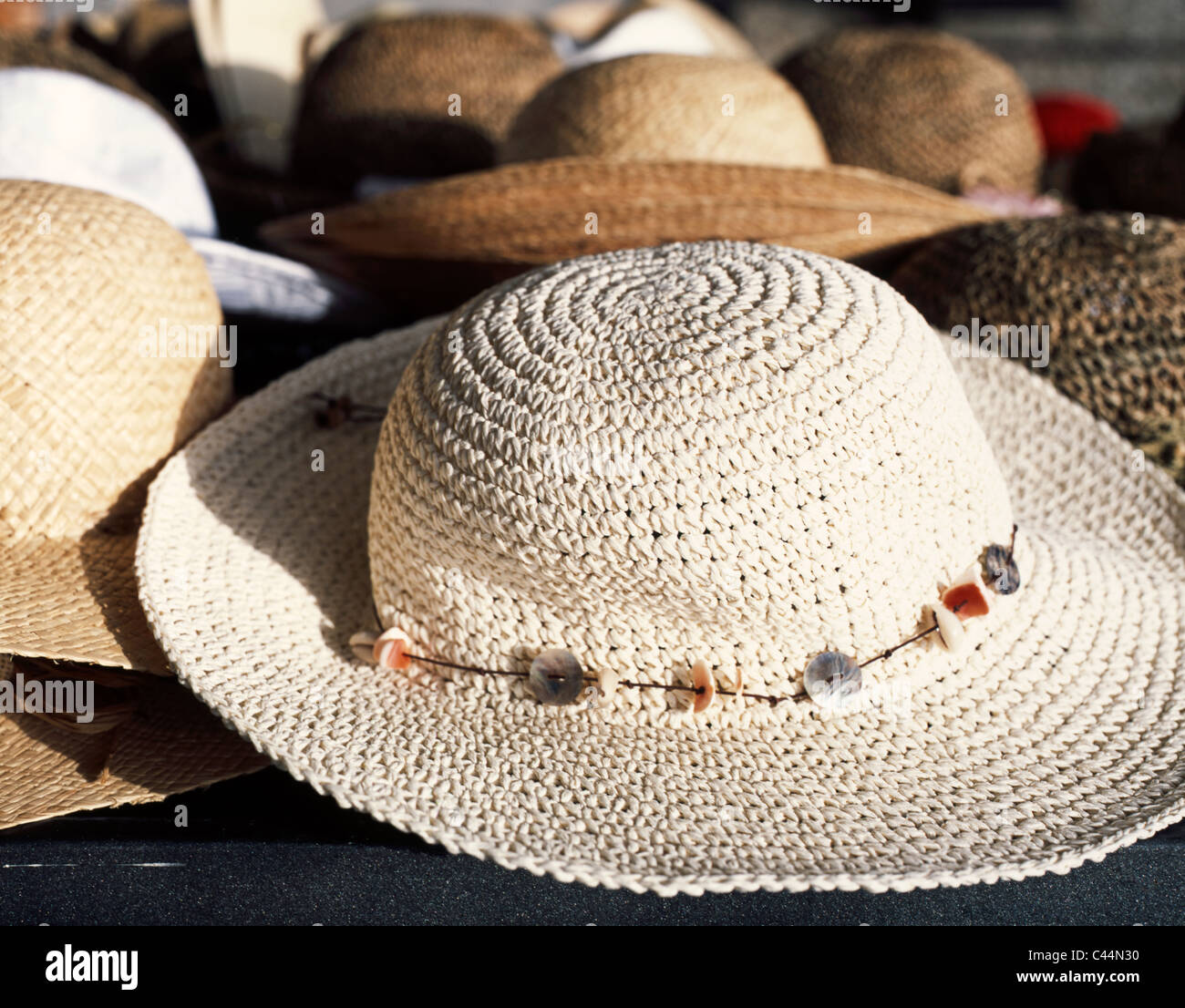Female straw hat with a decorative necklace used as a kind of ribbon on