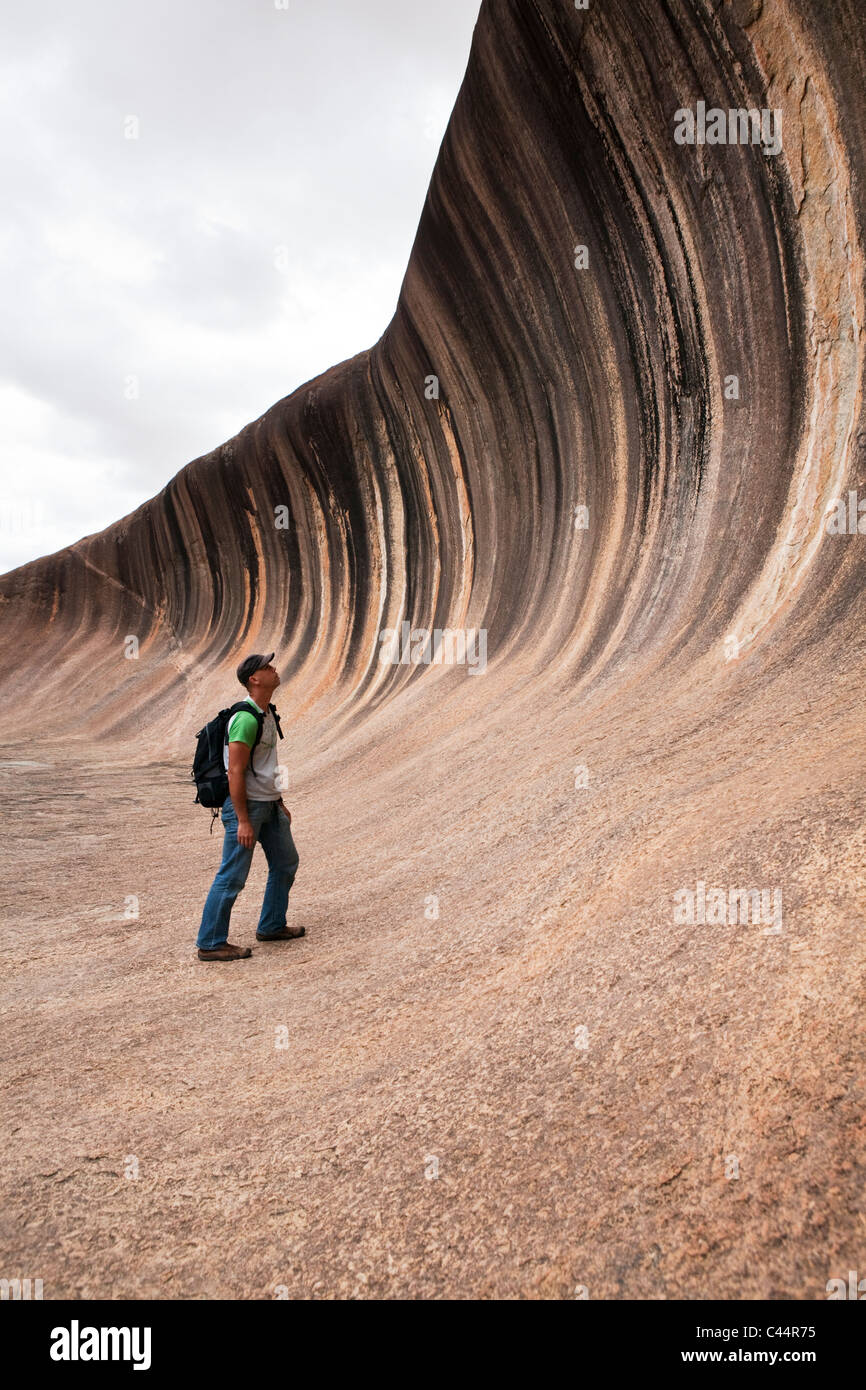 Hiker at Wave Rock - a natural rock formation near Hyden, Western Australia, Australia Stock Photo