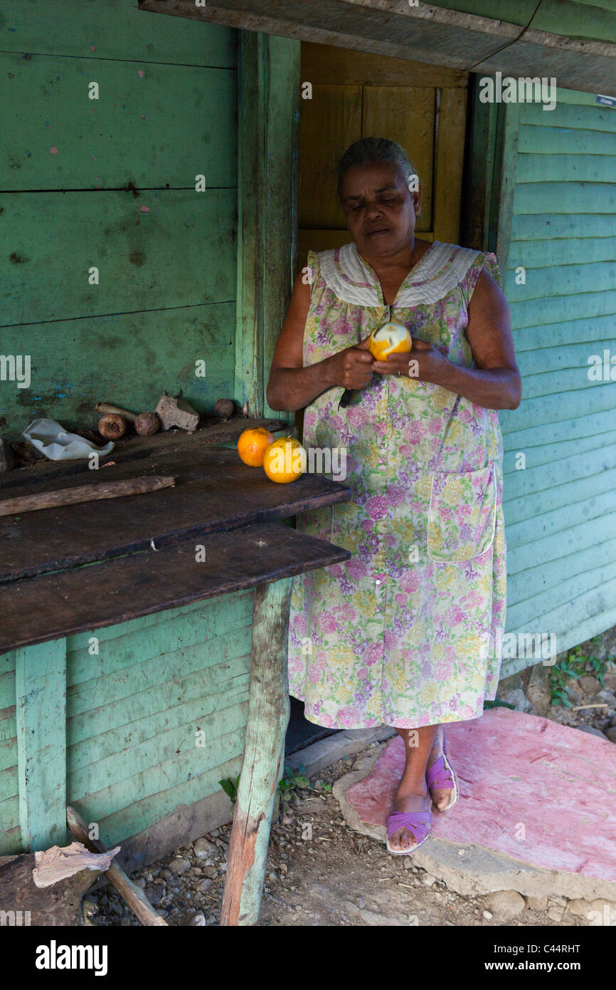 Village Woman peels Oranges, Punta Rucia, Dominican Republic Stock Photo