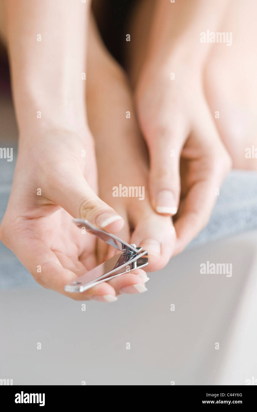 Woman using nail cutter Stock Photo Alamy