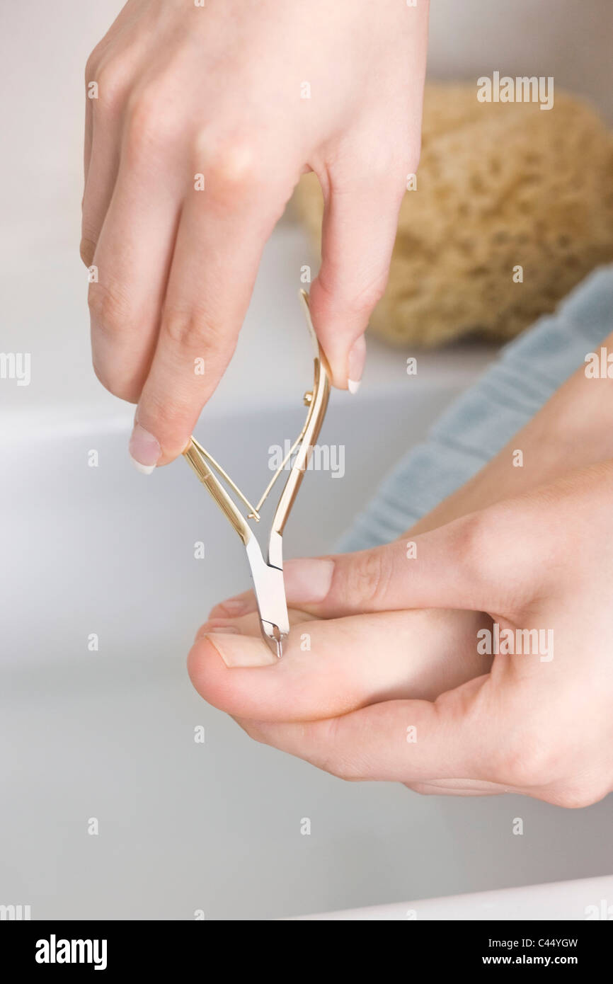 Woman using nail clippers Stock Photo Alamy