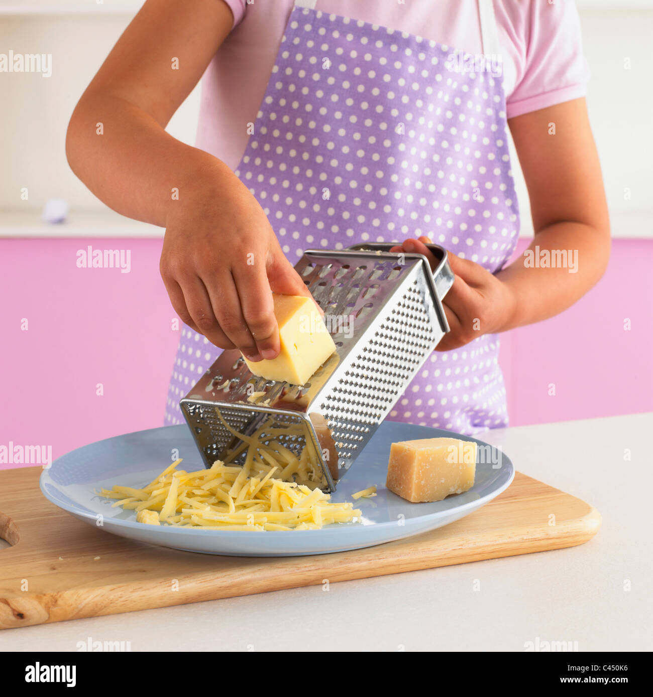 Girl grating cheese, close-up Stock Photo