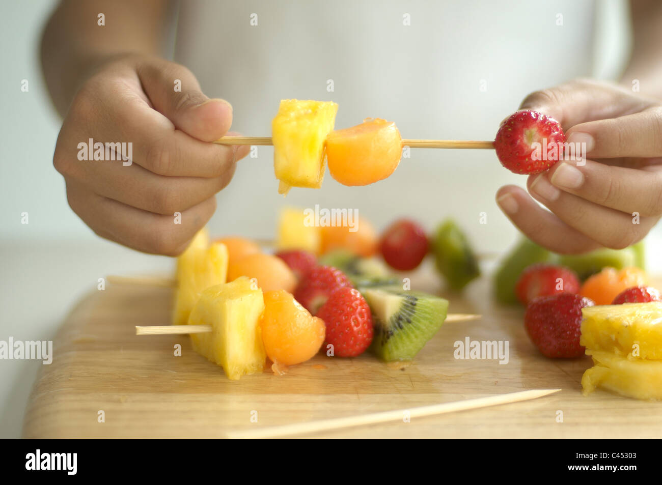 Girl making fruit kebab, closeup Stock Photo Alamy