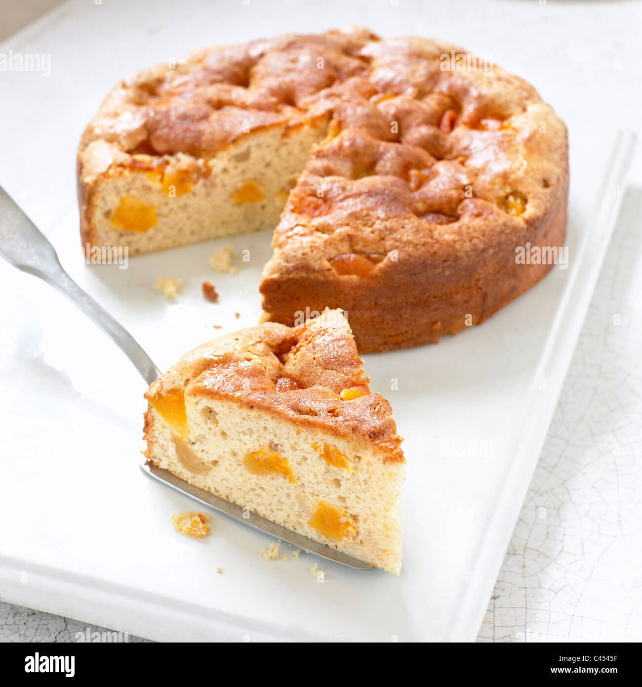 Apricot cake with single slice cut away, close-up Stock Photo