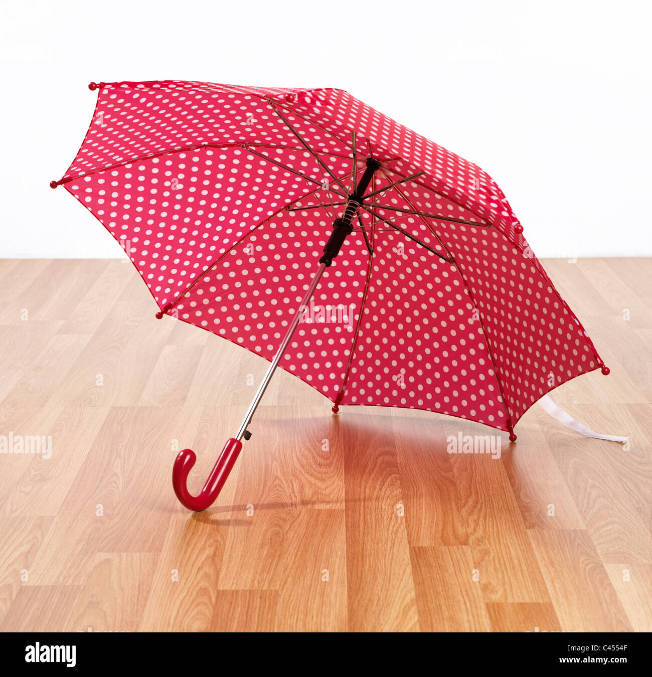 Open red and white spotted umbrella on floor hires stock photography