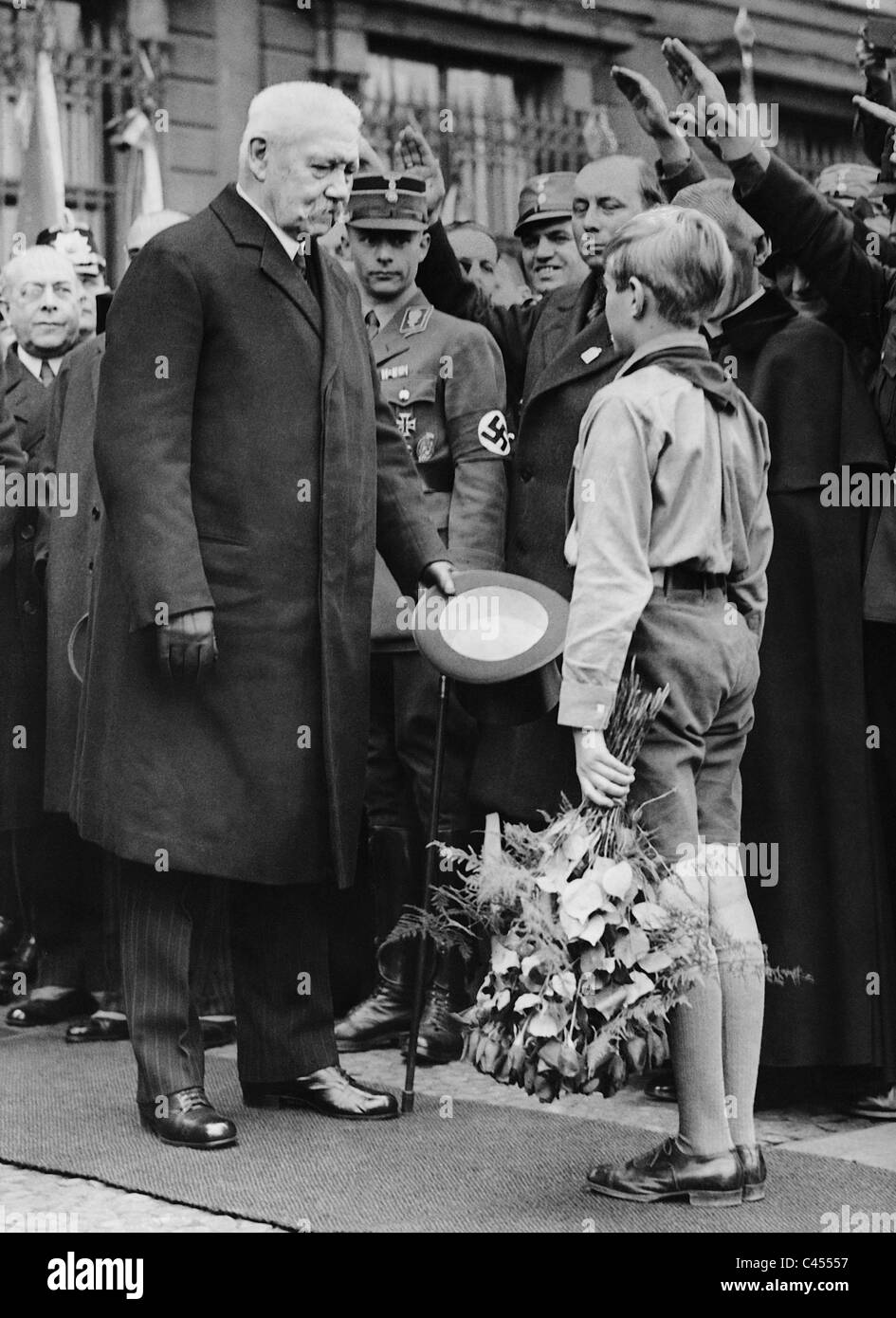 Harald Quandt hands a bouquet of flowers to President von Hindenburg Stock Photo