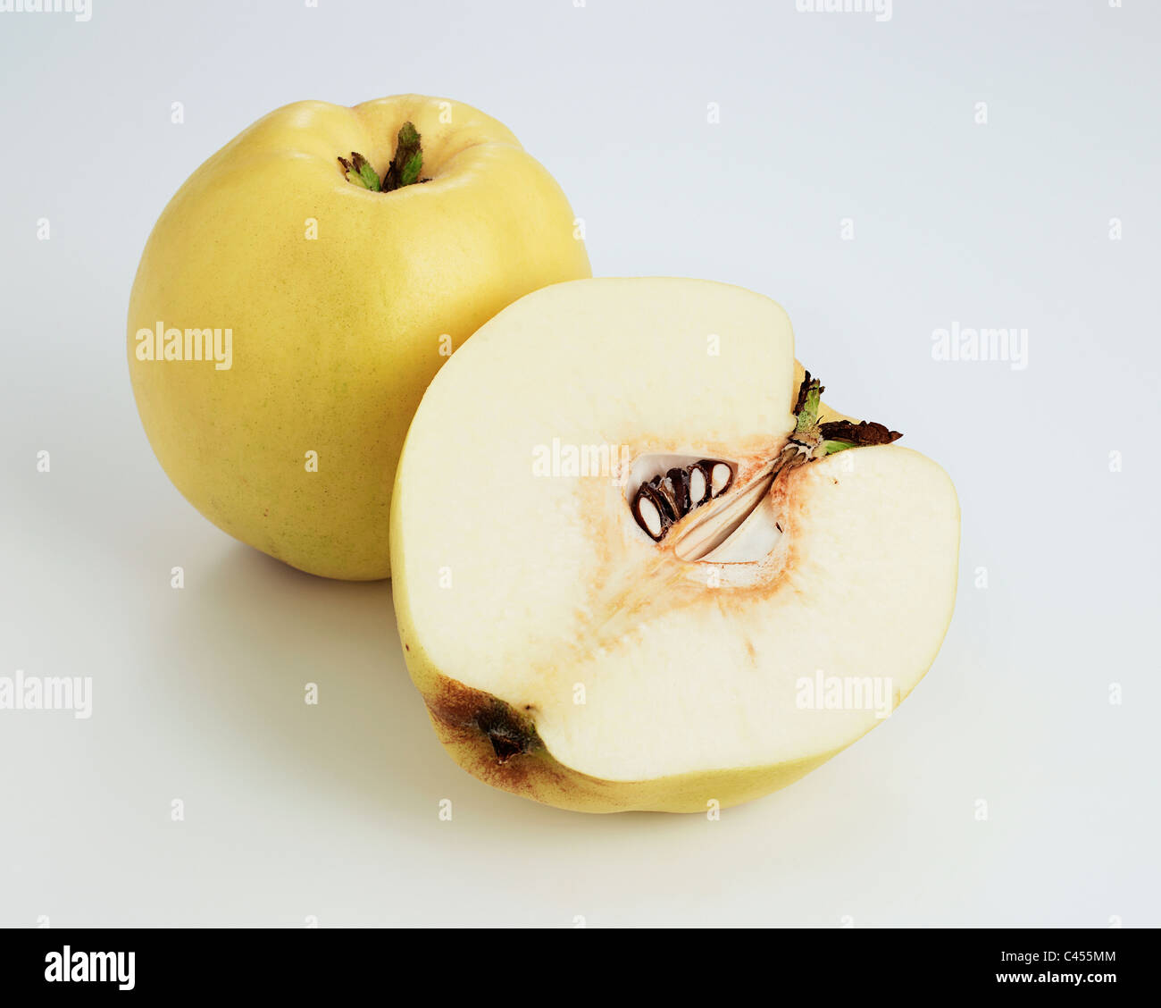 Whole and halved quince on white background, close-up Stock Photo