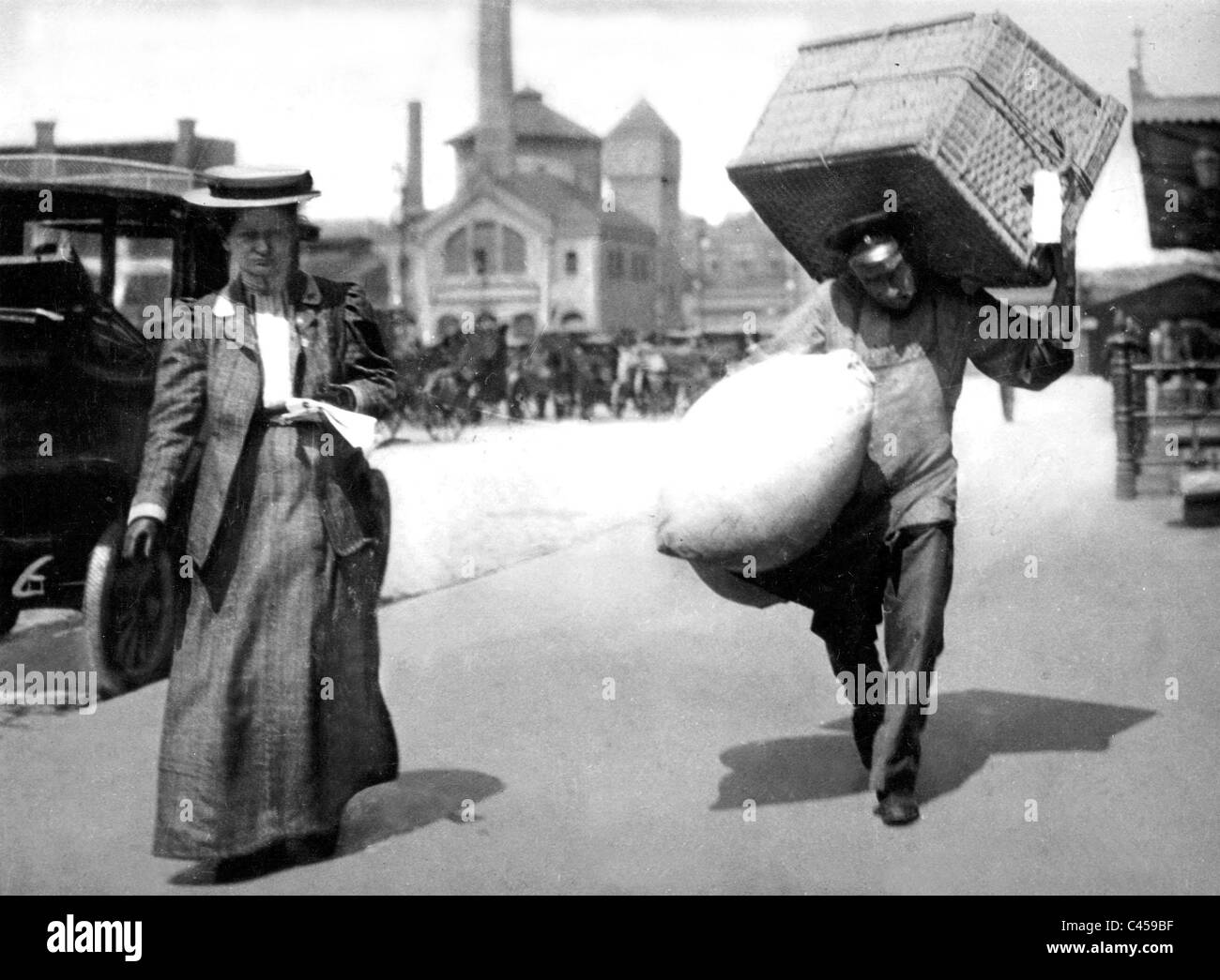 Porter carries luggage, 1909 Stock Photo