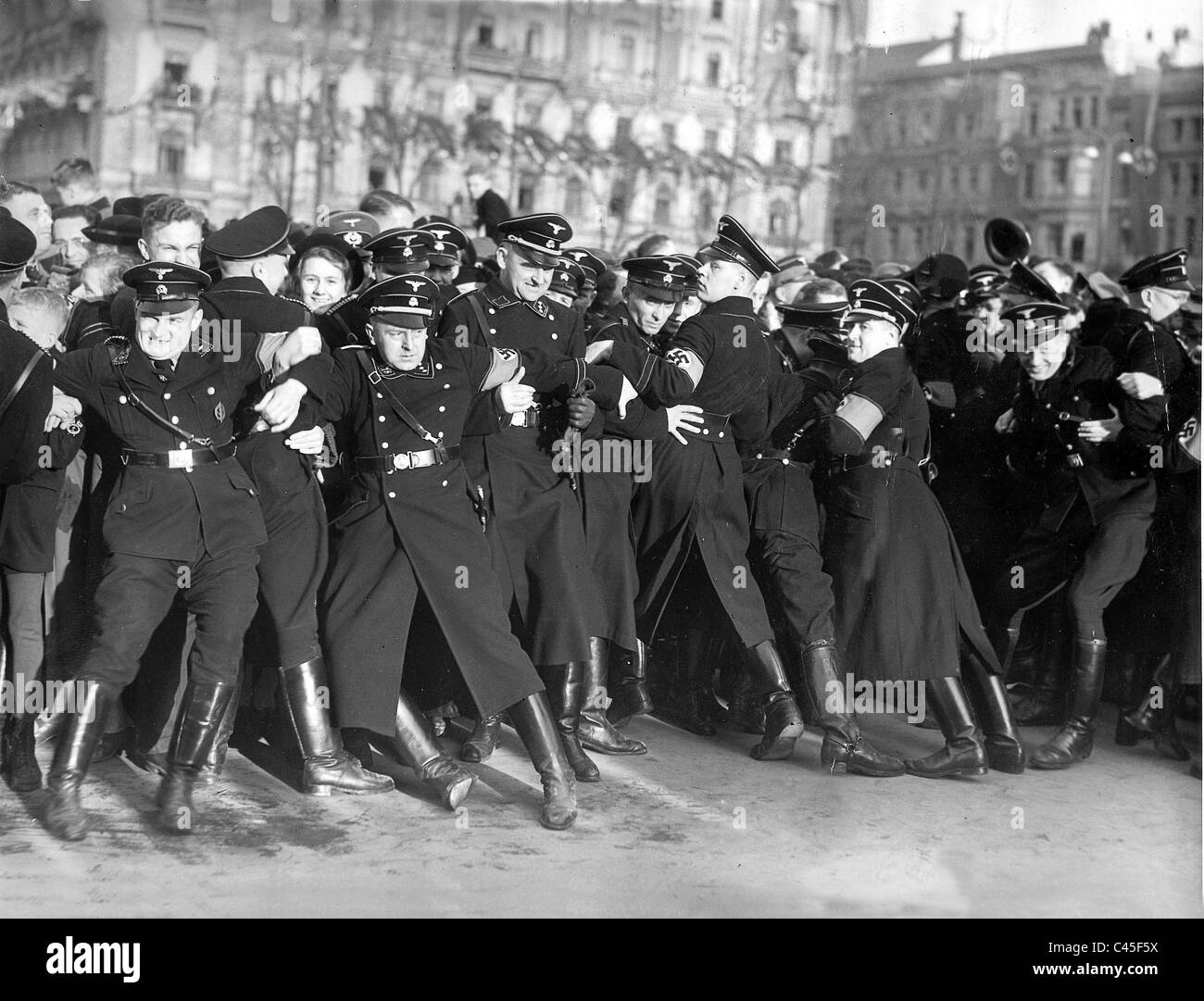 SS men hold back pedestrians during the return of Hitler from Vienna Stock Photo