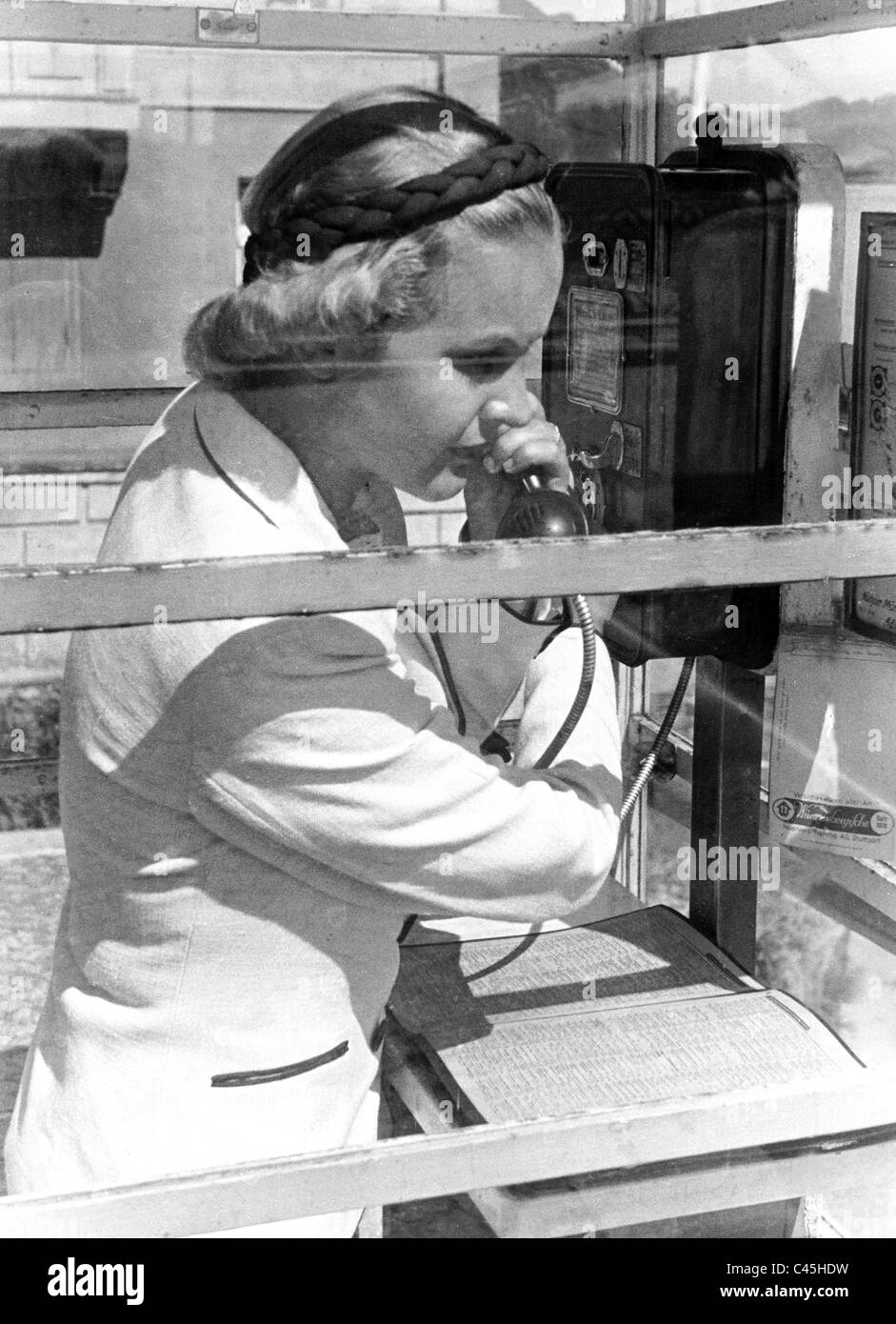 Woman telephones on a pay phone, 1941 Stock Photo