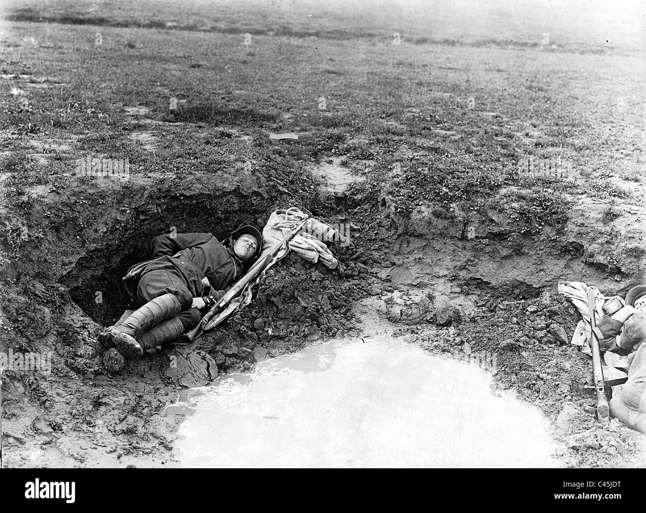 Resting in a shell hole, 1917 Stock Photo