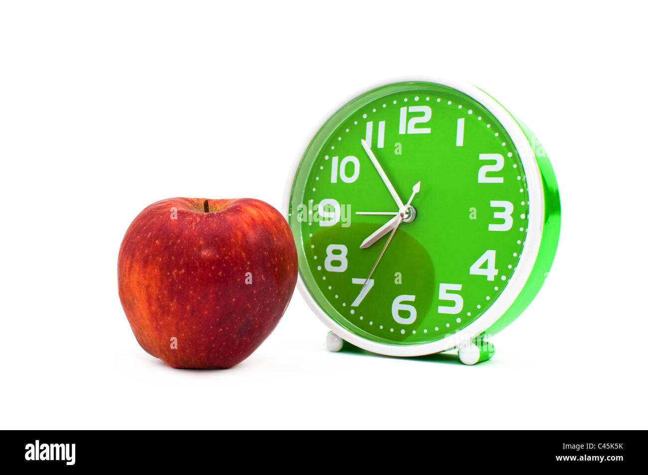 Alarm clock on the white and an apple Stock Photo Alamy