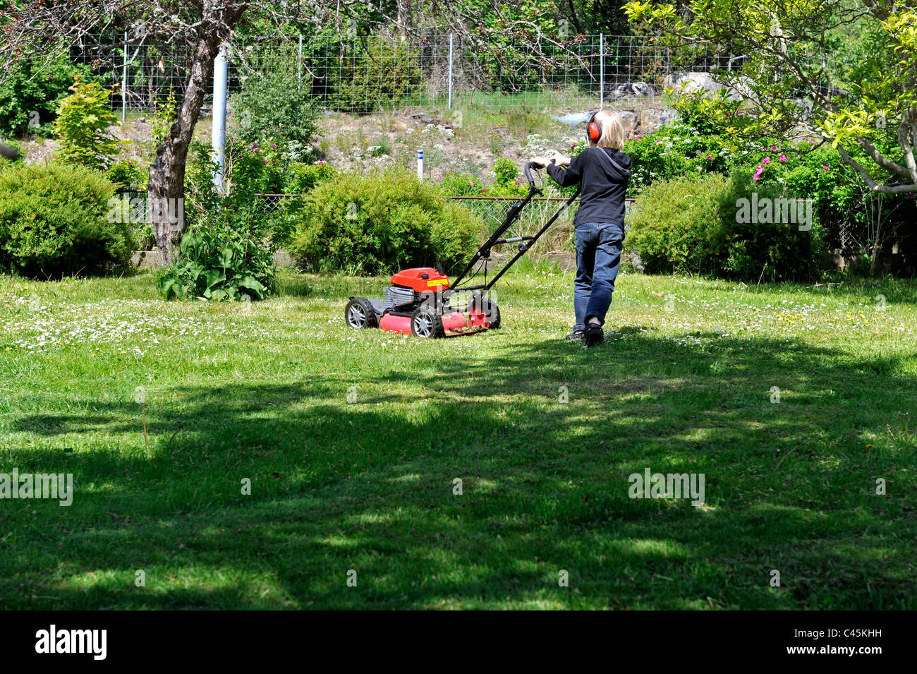 Young boy cutting grass with a lawn mover Stock Photo - Alamy