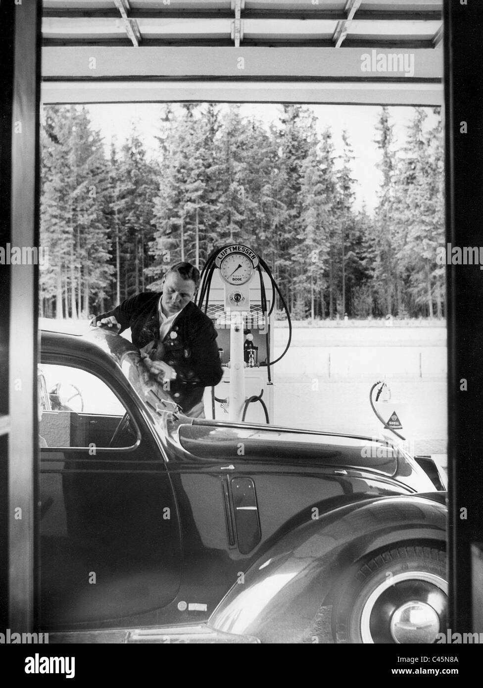 Gas station attendant while washing windows at the Reich highway Munich-Salzburg, 1939 Stock Photo