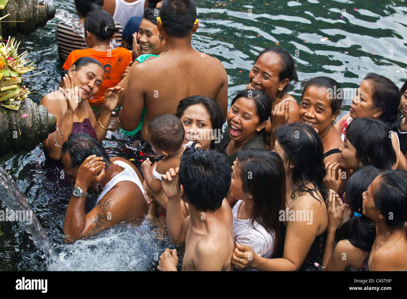 People bath in the waters of the cold spring at the PURA TIRTA EMPUL TEMPLE  during the Galungan Festival - TAMPAKSIRING, BALI Stock Photo