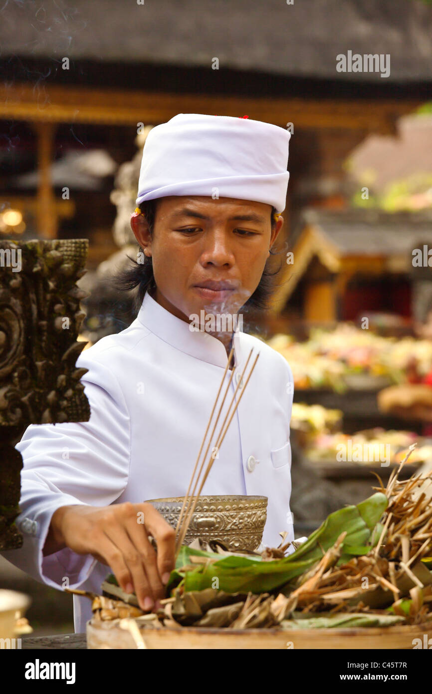 A Hindu priest offers incense at the PURA TIRTA EMPUL TEMPLE during the