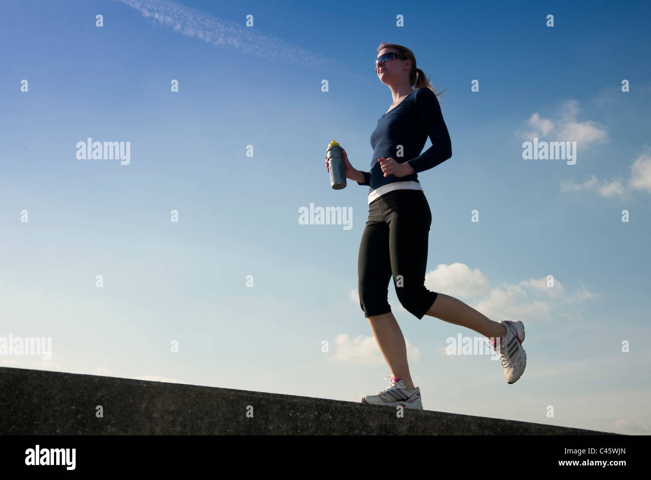 woman running carrying drinks bottle Stock Photo Alamy