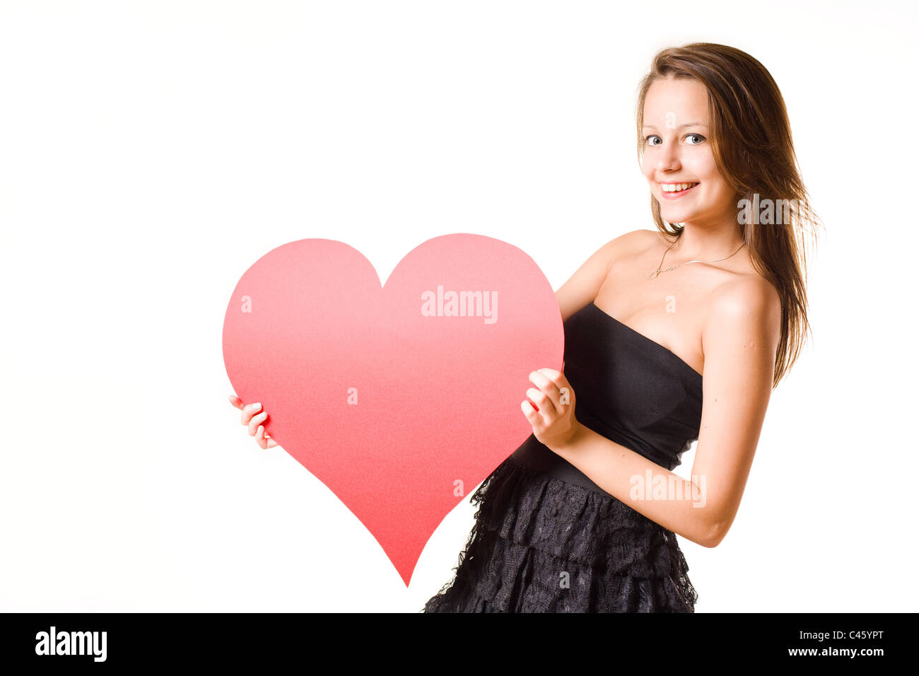 I love... beautiful young brunette girl holding big red heart, isolated ...