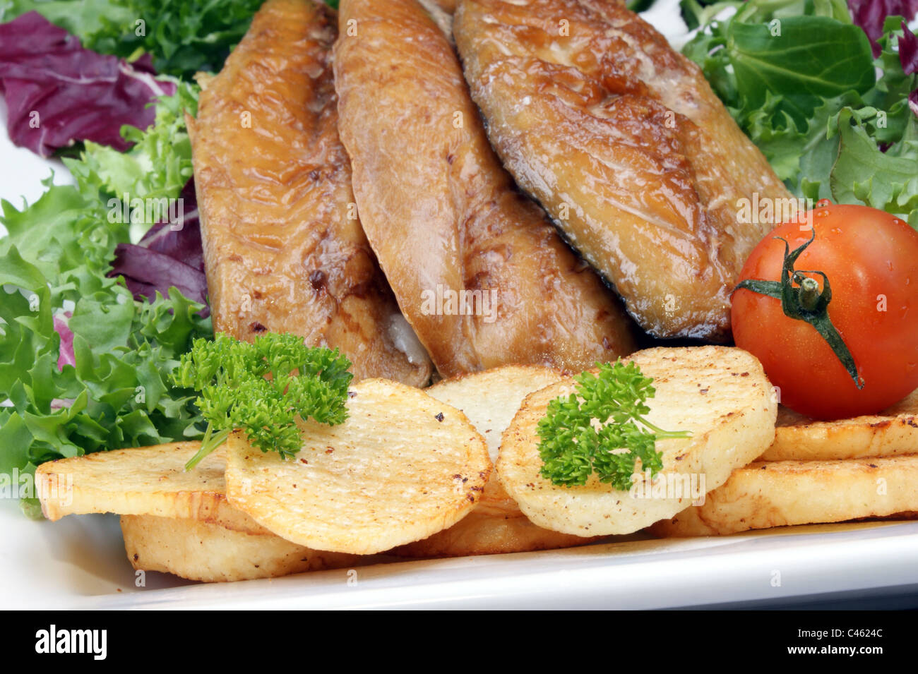 smoked mackerel fillets with fried potatoes and tomato Stock Photo