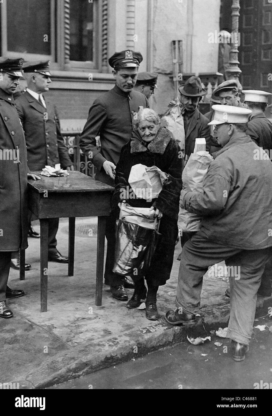 Police officers distribute food to people in need, 1932 Stock Photo