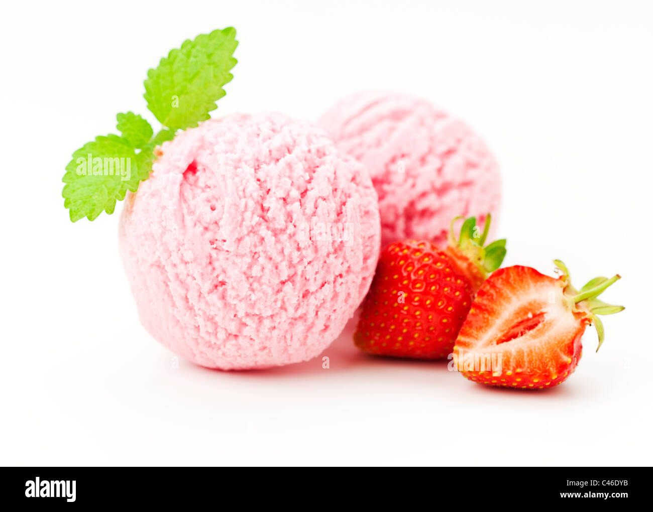 two scoops of strawberry ice cream, strawberry fruit, mint leaf, white background Stock Photo