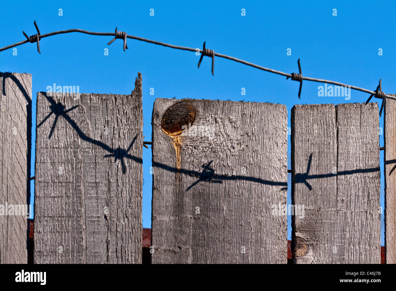 wooden fence of barbed wire against the blue sky Stock Photo - Alamy