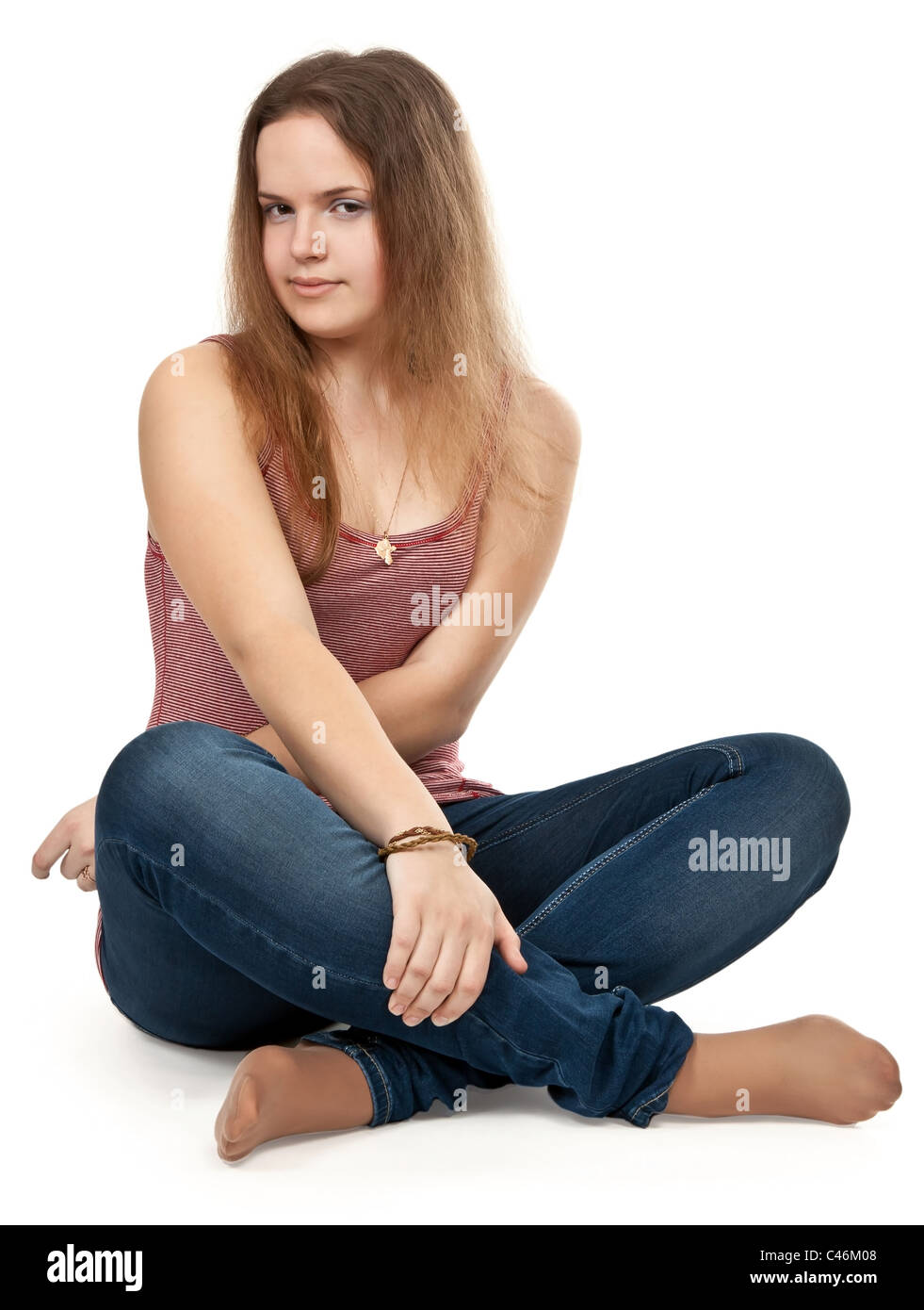 girl sitting in the lotus position in jeans on a white background