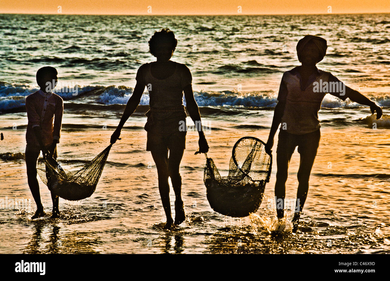 Fishermen at sunset on Calva Beach in Goa, India Stock Photo