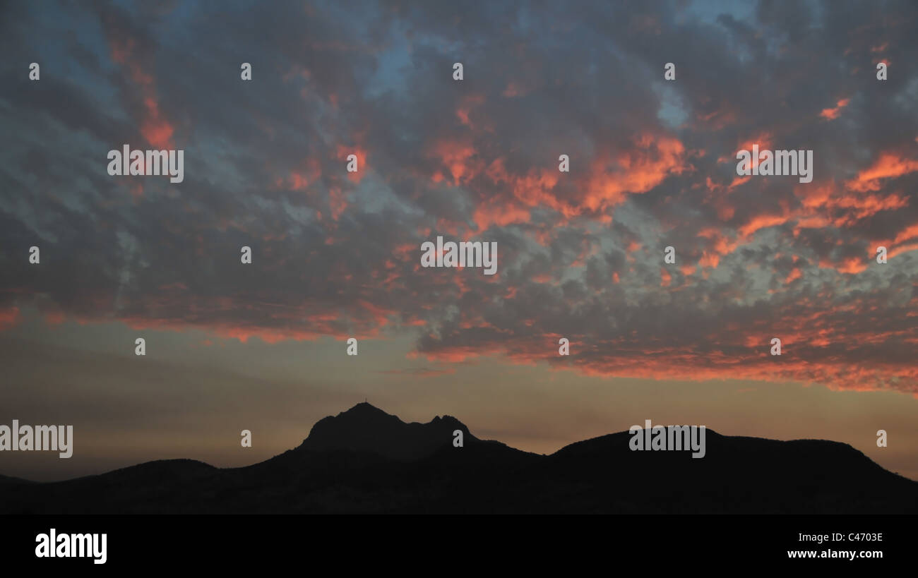 Red sunset sheet of altocumulus clouds above black silhouette mountain peaks ridge, Andes, Ruta 5, north of Santiago, Chile Stock Photo