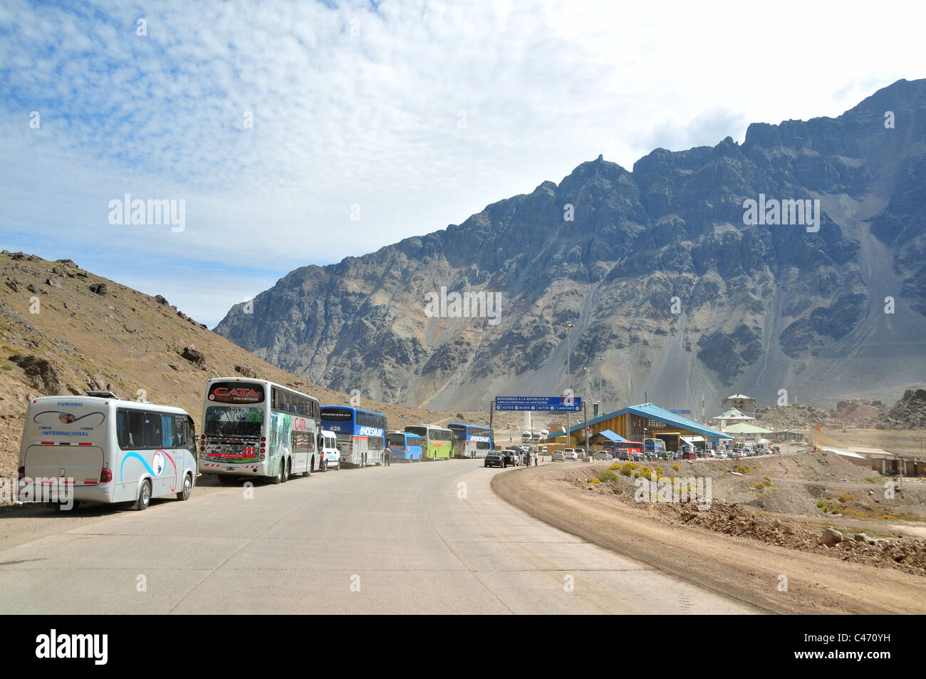 Blue sky white cloud mountain view Argentine traffic queue buses cars, Chilean Border, Ruta 7, Uspallata Pass, Andes, Argentina Stock Photo