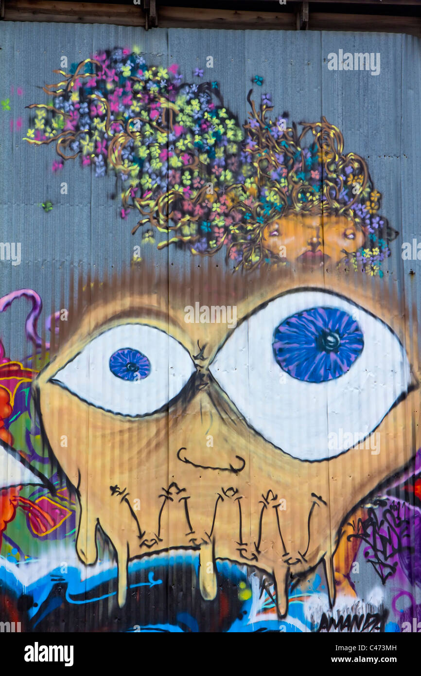 A Picasso-like mural of a face with bulging eyes and a woman with flowers in her hair. Stock Photo