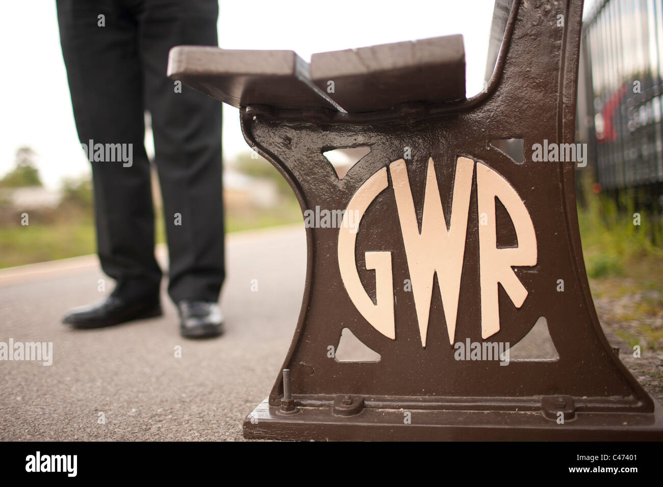 Railway heritage GWR great western railway bench on the Chiltern line with passengers feet in background Stock Photo