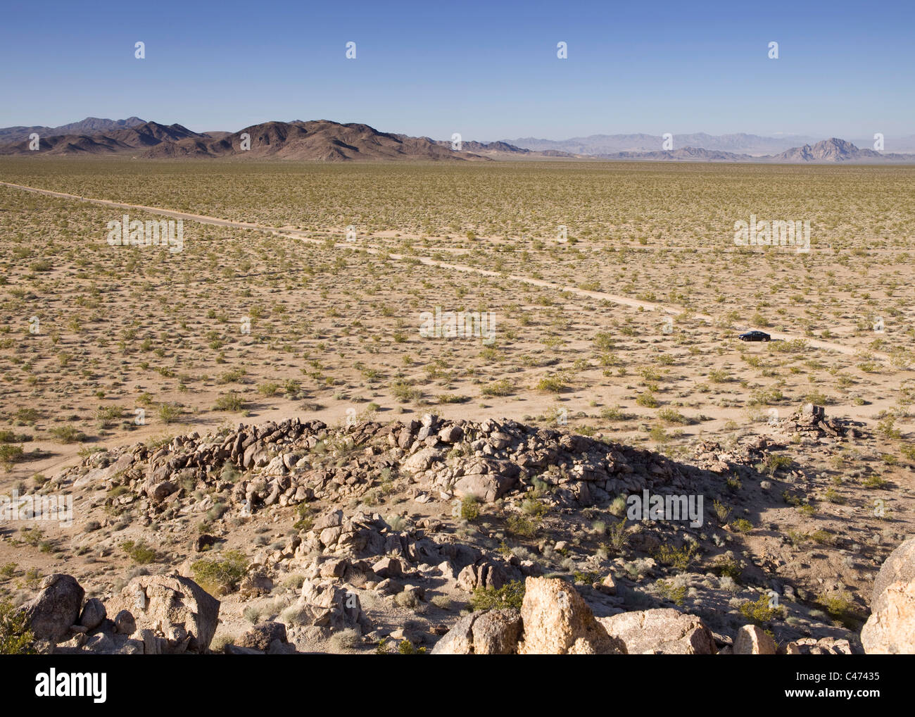 A dirt road crosses the Mojave desert landscape - California USA Stock Photo