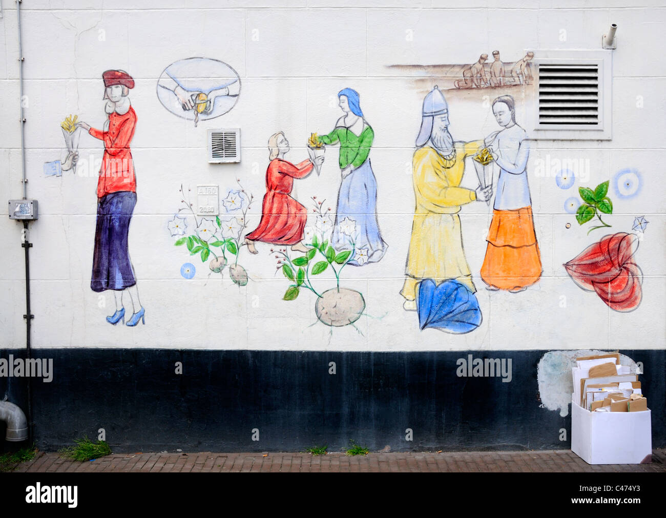 Nijmegen, Netherlands. Wall painting and cardboard for recycling. Historical figures eating chips Stock Photo