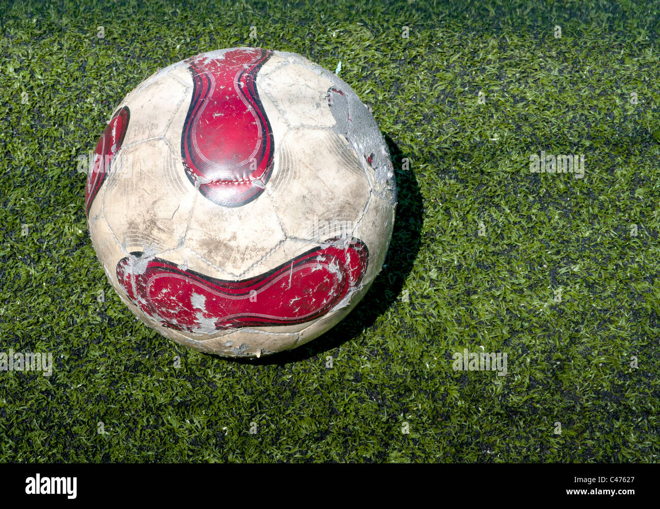 Red and white Football ball on the grass field Stock Photo