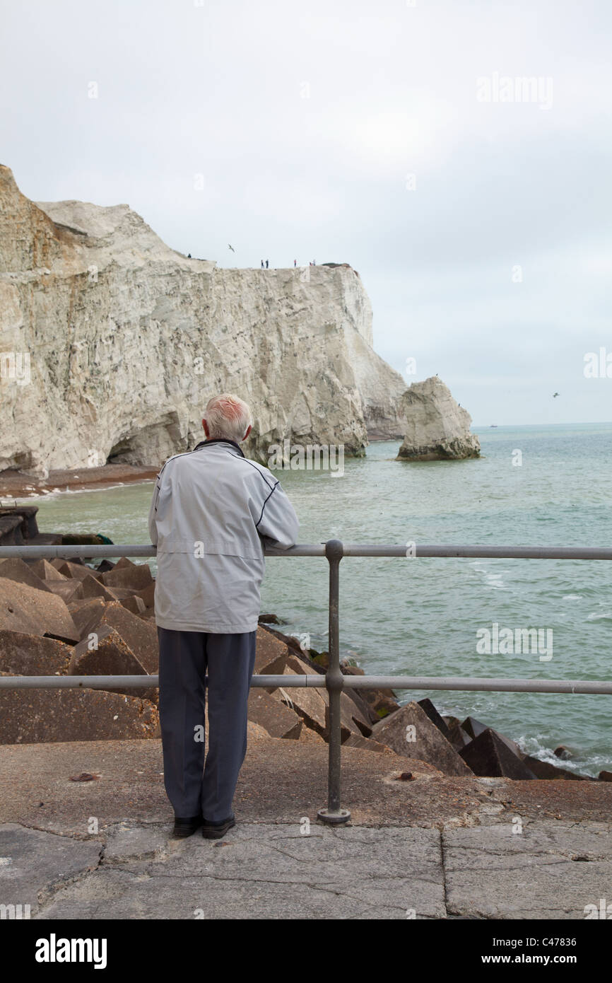 Old man looking at white cliffs in Seaford, UK Stock Photo