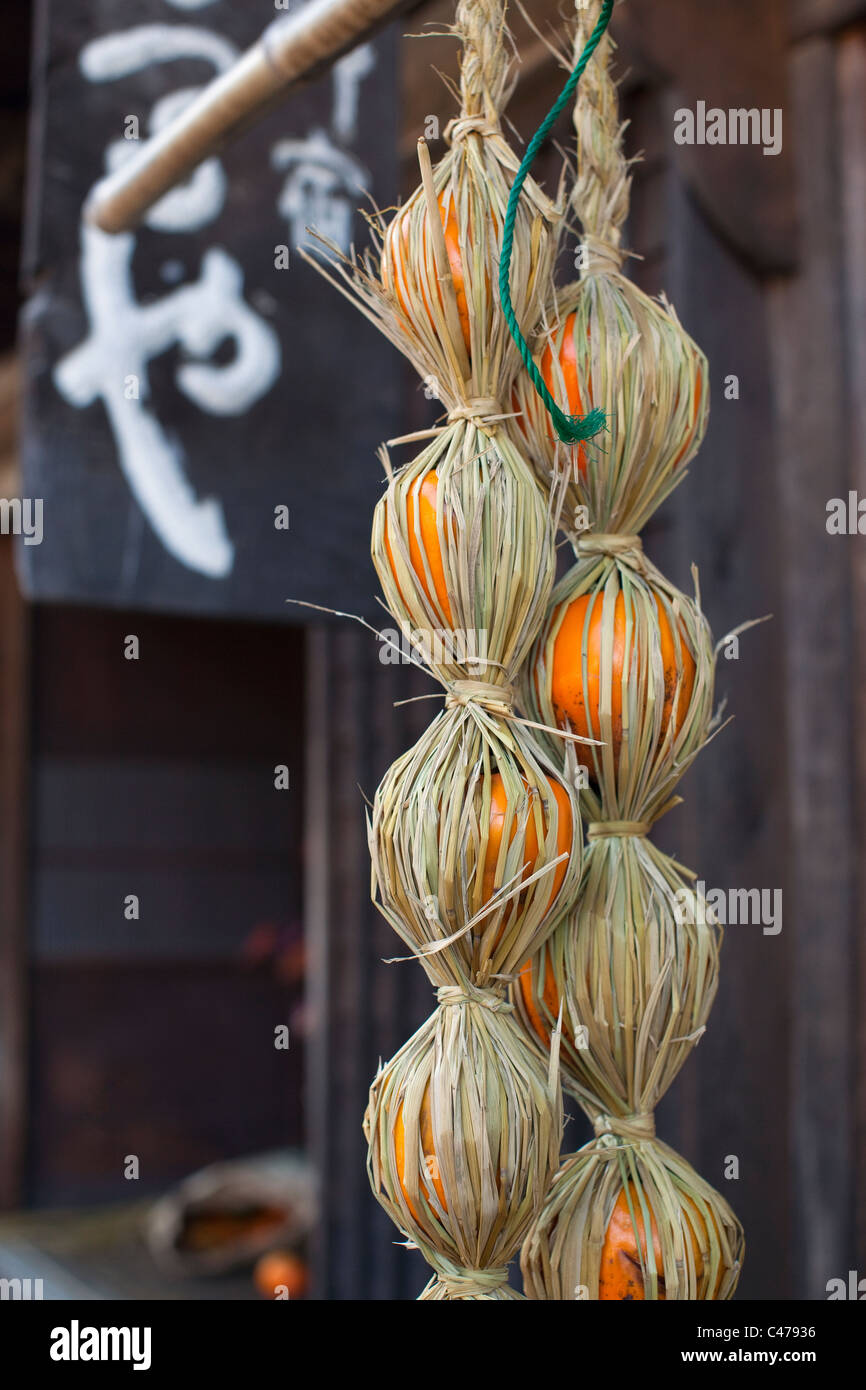 Persimmons wrapped in straw on Nakasendo post road between Magome and Tsumago, Kiso Valley. Stock Photo