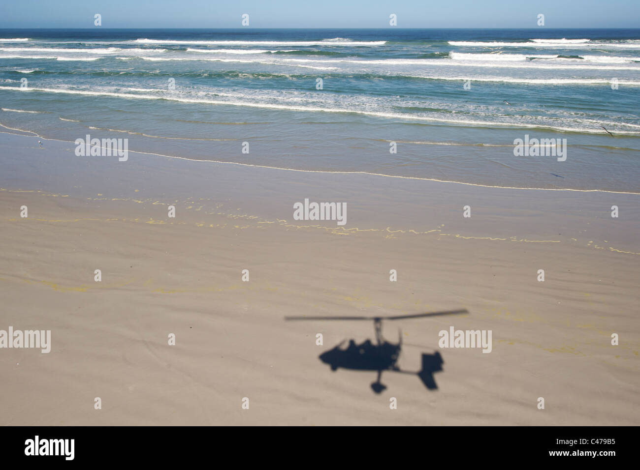Shadow of a gyrocopter flying along the beach on the Cape West Coast in South Africa. Stock Photo