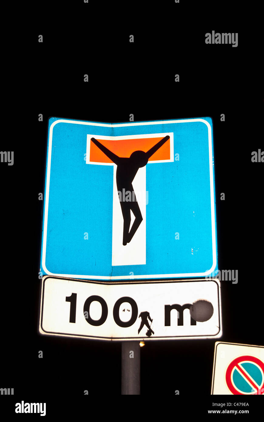 road sign  reinterpreted by a street artist as a crucifixion, Milan Italy Stock Photo