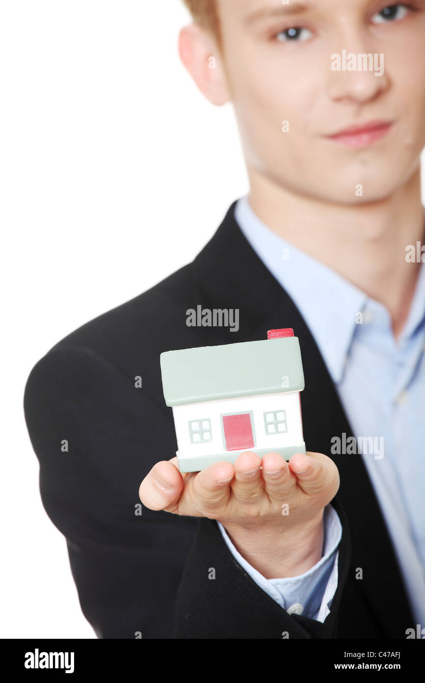 Young businessman holding house model - real estate concept. Isolated ...