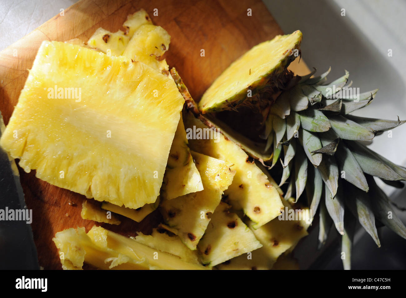 Fresh pineapple fruit sliced with knife with serated edge Stock Photo